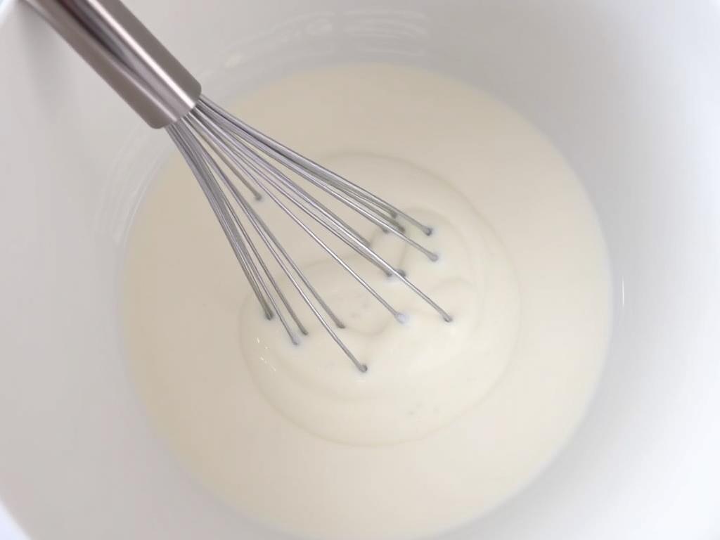 Jogurt naturalny mieszany z wodą w misce - przygotowanie zamiennika maślanki