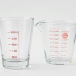 Standardowa szklanka o pojemności 250 ml obok miarki kuchennej